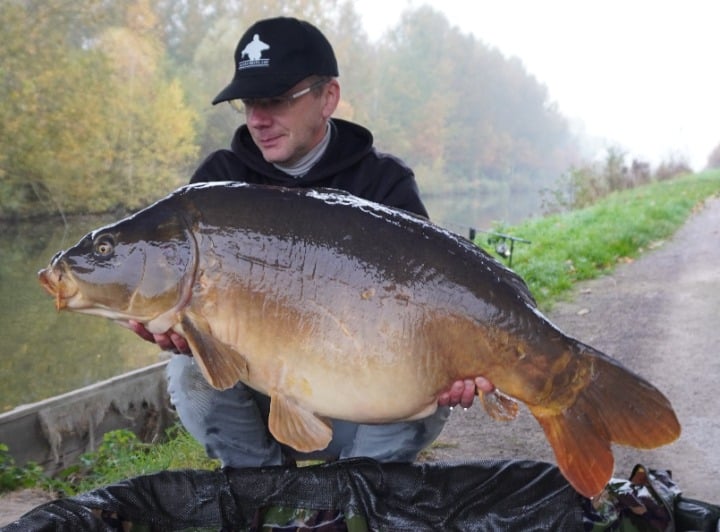 Fabrice tenant une grosse carpe miroir capturée dans un canal