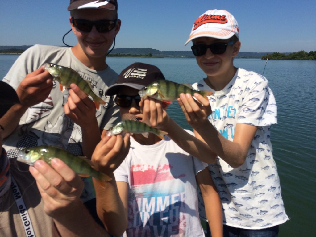 Jeunes pêcheurs présentant leurs belles perches capturées lors d'un stage de pêche au lac de Madine.